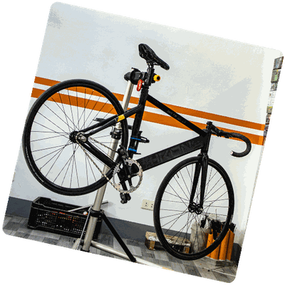 Vélo noir à bandes orange sur pied d'atelier